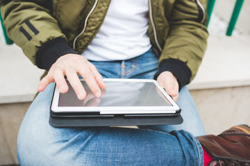 Close up on the hand of a man using a tablet, tapping the touchs