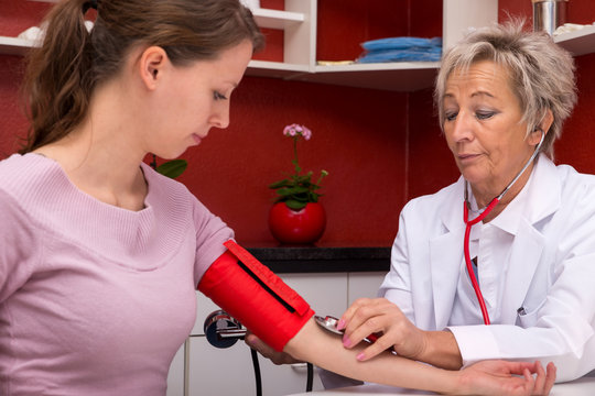 Ärztin misst junger Frau den Blutdruck
