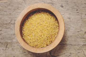 Raw Bulgur on wooden background