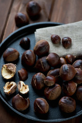 Close-up of a frying pan with roasted chestnuts, selective focus