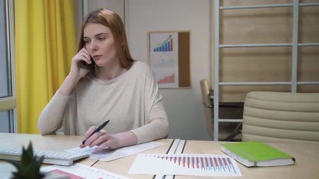 Woman takes a call at the workplace.