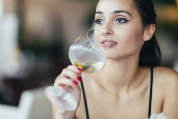 Attractive woman tasting white wine