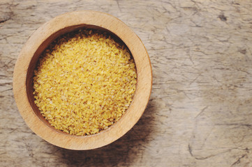 Raw Bulgur on wooden background