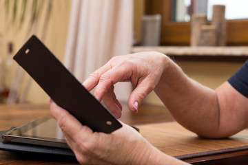 Nahaufnahme Finger tippen auf Smartphone, Tablet im Hintergrund