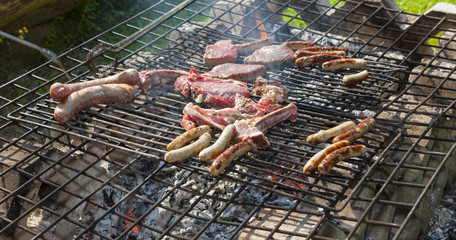 Würstchen und Steaks liegen auf einem Naturgrill, Hesssen, Deutschland, Europa