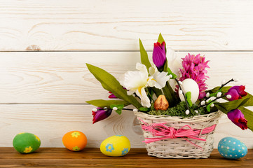 Easter arrangement and easter eggs on wooden background.