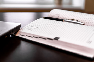 Diary with a pen on the desktop.