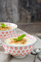 Rice pudding with cinnamon on wood
