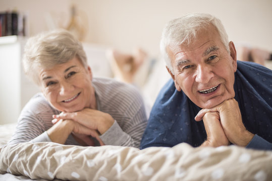 Cheerful senior marriage resting in the bedroom