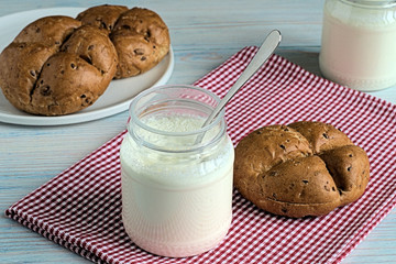 Yogurt.   Yogurt in a jars and buns on a blue wooden background.
