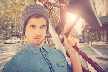 Composite image of portrait of hipster carrying bicycle