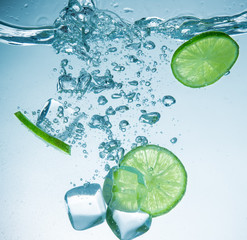 Limes with water splash and ice cubes