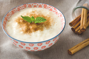 Rice pudding with cinnamon in bowl 
