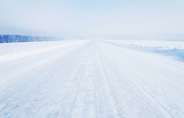 Straight empty icy highway in cold winter weather