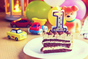 Baby boy first birthday party. Focus on cake with blurred multicolored background. Image with vintage filter