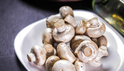 White mushrooms on a black table white plate