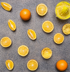 cooking and vegetarian concept orange juice, hand juicer and oranges on granite  rustic background top view close up