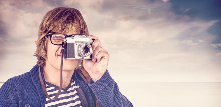 Composite image of hipster taking pictures with an old camera 