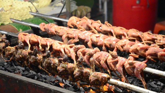 Grilled quail for sale people in market fair in annual festival of Wat Lam Pho in Nonthaburi, Thailand.