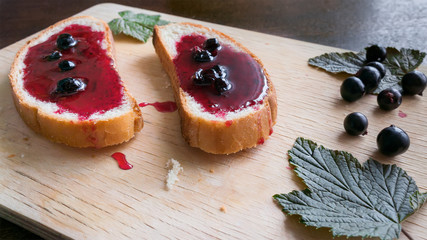 Toast with currant jam on wooden table