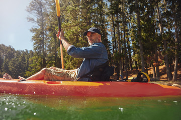 Senior man paddling a kayak