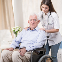 Obraz premium Nurse with old man on wheelchair