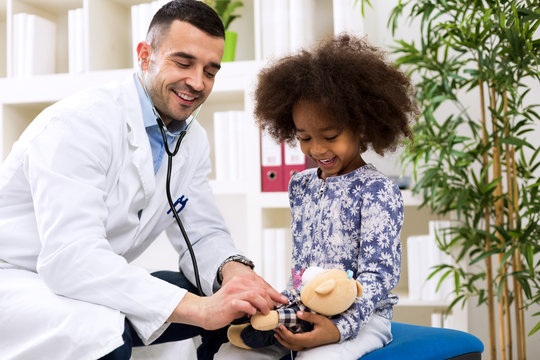 Doctor pediatrician playing with his patient before examining
