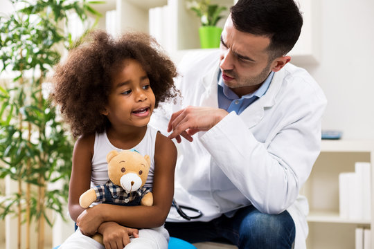 Pediatrician talking with his small patient