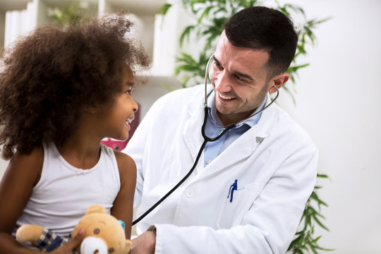 Positive pediatrician doctor examining kid