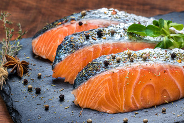 Fresh salmon portions with herb and pepper seasoning.