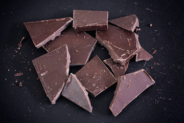 Broken chocolate heap on a black background