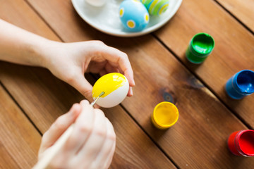 Fototapeta na wymiar close up of woman hands coloring easter eggs