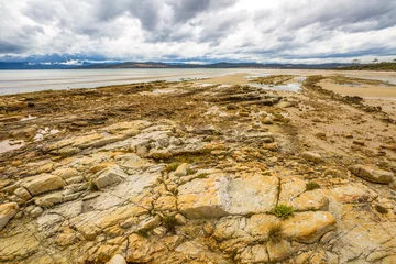 Fotobehang Nubeena Road, Koonya drammatic landscape with cloudy sky and rocky beach in the Tasman Peninsula in Tasmania, Australia. © bennymarty