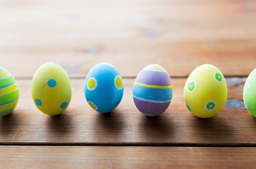 close up of colored easter eggs on wooden surface