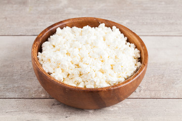 Curd in brown bowl on wooden table background