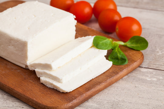 Traditional Greek Feta cheese and tomato on wooden table