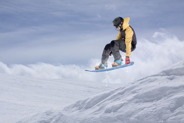 Flying snowboarder on mountains. Extreme sport.