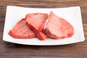 Raw beef steak on wooden table