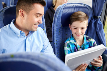 happy family with tablet pc sitting in travel bus