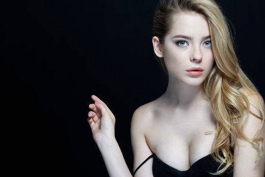 Beautiful Girl face. Perfect skin. Close-up of an attractive girl of European appearance on dark background.