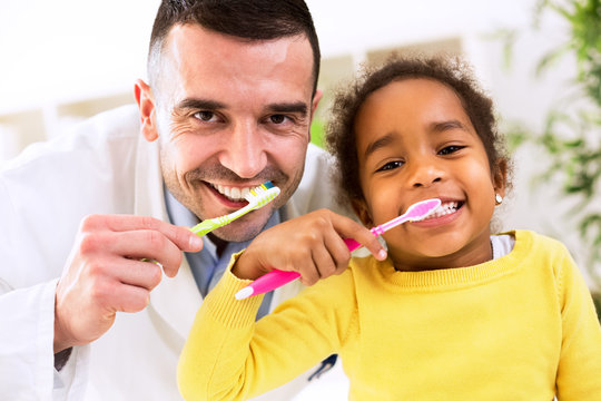 Pediatrician learn cute african girl brushing tooth