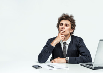 Pensive businessman looking up with concentration on grey background. Depression and crisis concept