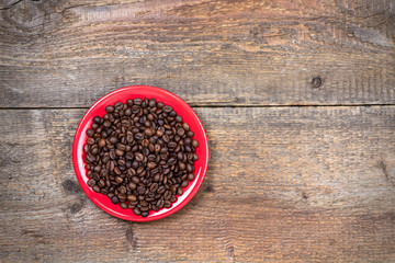 Coffeebeans on plate and dark wooden table