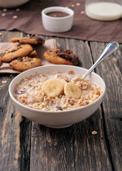 healthy breakfast of oatmeal with bananas in white bowl
