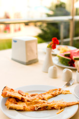 two slices of pizza / two slices of pizza on a table with a sunny window