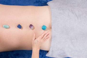 man Reiki Healer with Healing woman hand holding a stone