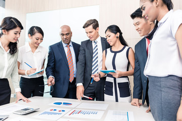 Business team discussing graphs and numbers in meeting