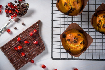 Chocolate muffins with a chocolate bar and red pomegranate fruit