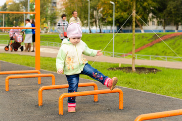 Fototapeta na wymiar Little girl playing on the playground