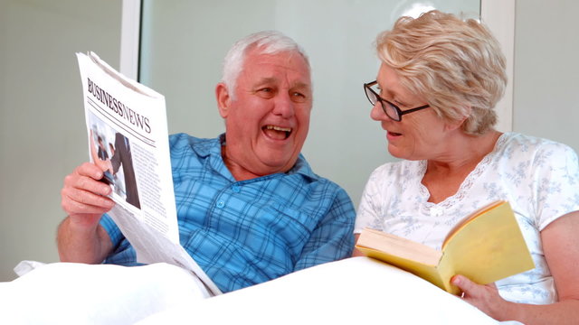 Smiling senior couple reading newspaper